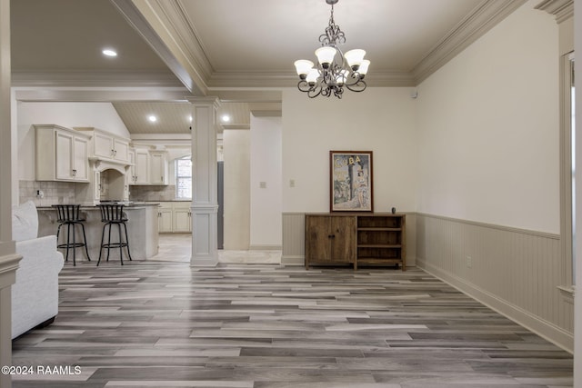 interior space with crown molding, light hardwood / wood-style flooring, and an inviting chandelier