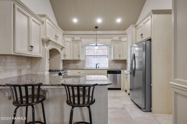 kitchen with a kitchen breakfast bar, dark stone countertops, stainless steel appliances, and vaulted ceiling