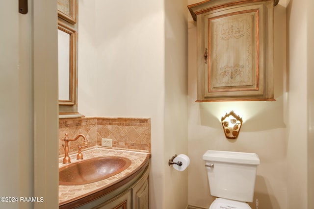 bathroom featuring vanity, backsplash, and toilet