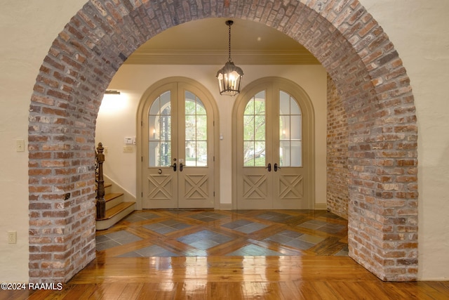 interior space with french doors, crown molding, and hardwood / wood-style floors