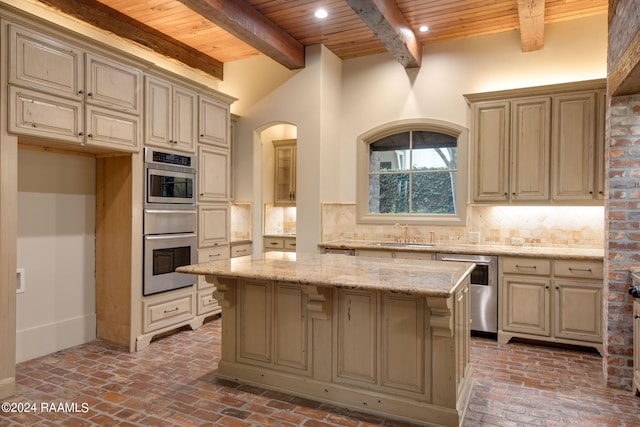 kitchen with light stone countertops, decorative backsplash, a center island, and stainless steel dishwasher