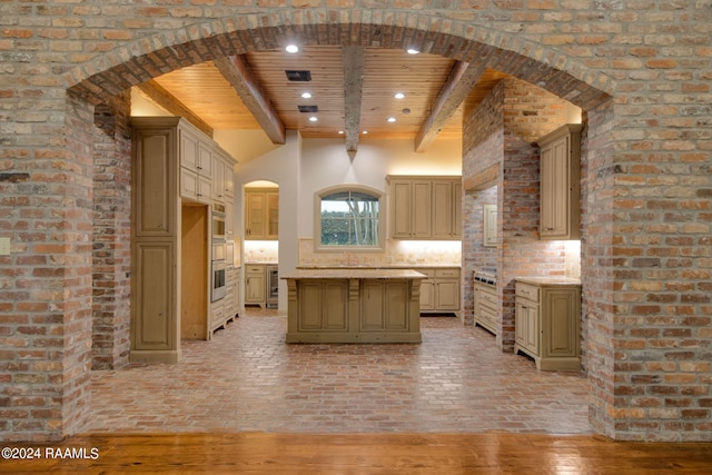 kitchen featuring beamed ceiling, decorative backsplash, a kitchen island, wood ceiling, and light wood-type flooring