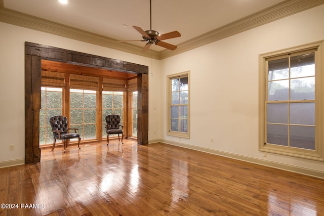 unfurnished room with crown molding, plenty of natural light, and hardwood / wood-style floors