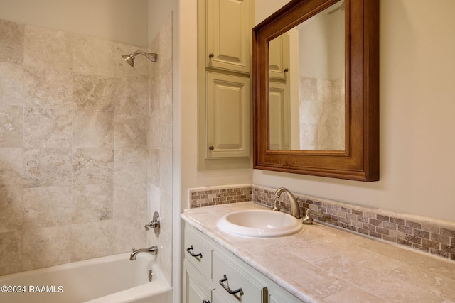 bathroom featuring vanity and tiled shower / bath