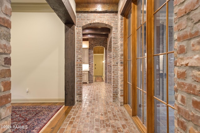 corridor with beam ceiling and brick wall