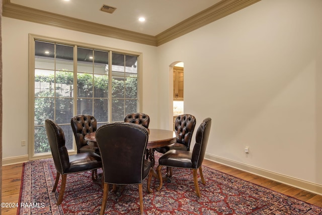 dining room featuring hardwood / wood-style floors and crown molding