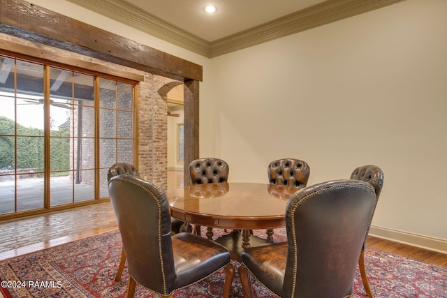 dining area with wood-type flooring and ornamental molding