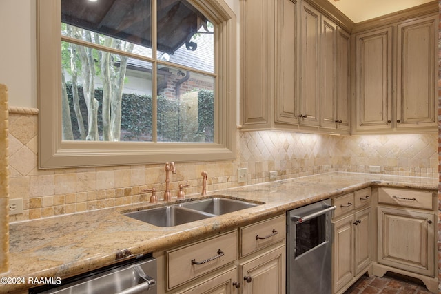 kitchen featuring dishwasher, light brown cabinets, backsplash, sink, and light stone countertops