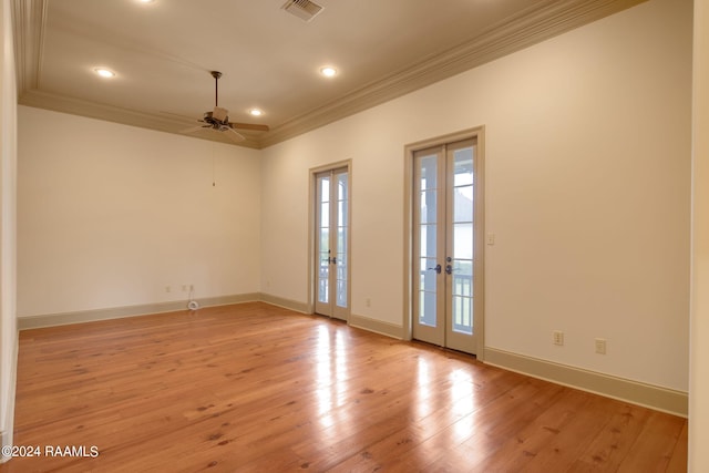 spare room featuring ceiling fan, light wood-type flooring, crown molding, and french doors