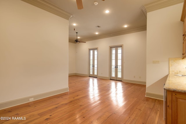 unfurnished room with ceiling fan, light wood-type flooring, crown molding, and french doors