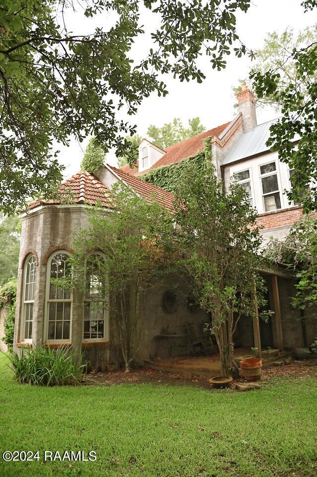 rear view of property featuring a lawn