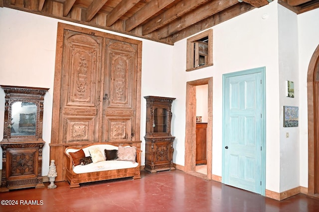 living area featuring concrete flooring and beam ceiling