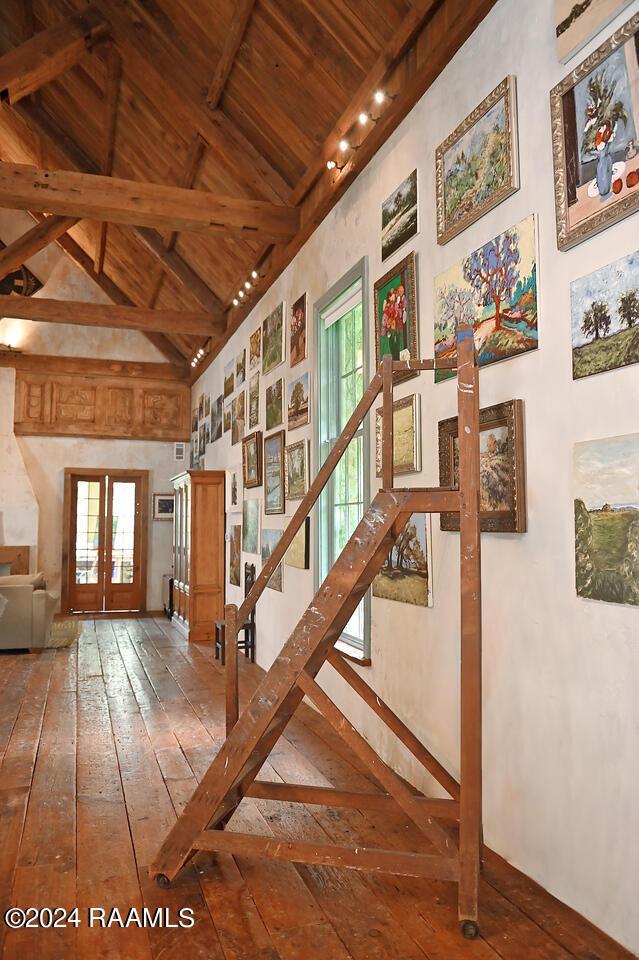 stairs with french doors, high vaulted ceiling, beam ceiling, wooden ceiling, and wood-type flooring