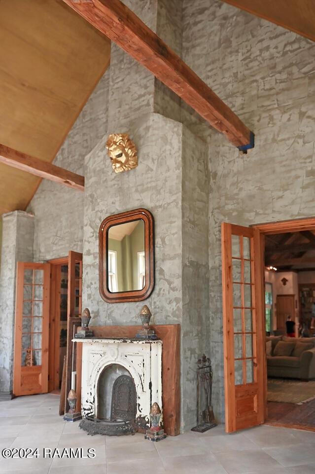 unfurnished living room featuring high vaulted ceiling, french doors, and beamed ceiling