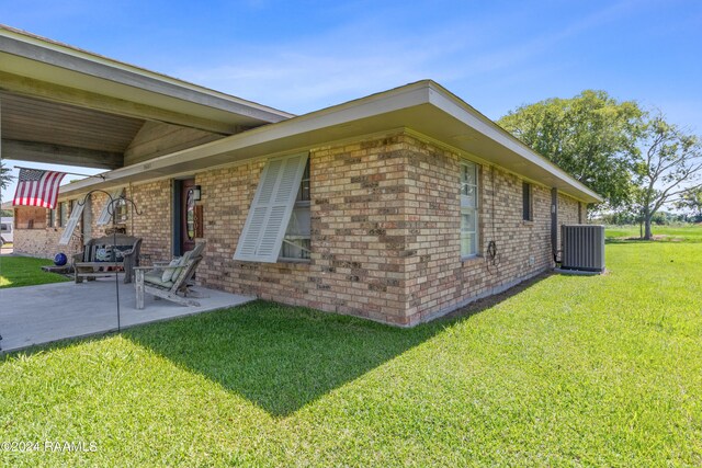 exterior space featuring a patio, central air condition unit, and a lawn