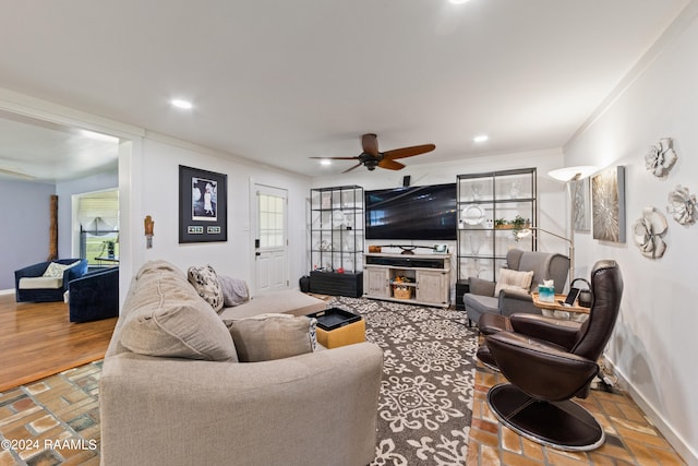 living room featuring a wealth of natural light, ceiling fan, crown molding, and hardwood / wood-style flooring