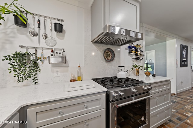 kitchen featuring high end stainless steel range, gray cabinetry, and light stone counters