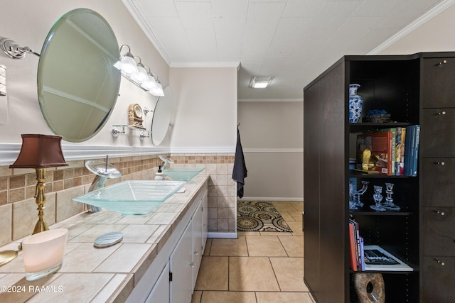 bathroom featuring backsplash, vanity with extensive cabinet space, dual sinks, tile flooring, and ornamental molding