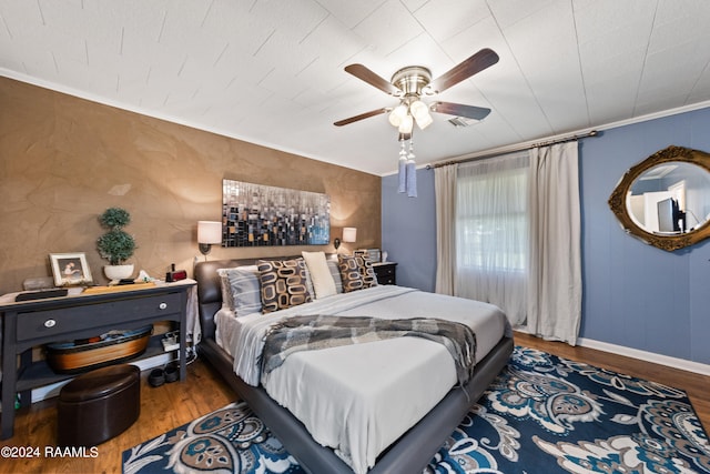 bedroom featuring wood-type flooring, ornamental molding, and ceiling fan