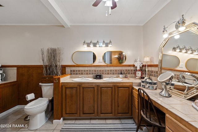 bathroom with vanity with extensive cabinet space, dual sinks, toilet, ceiling fan, and tile floors