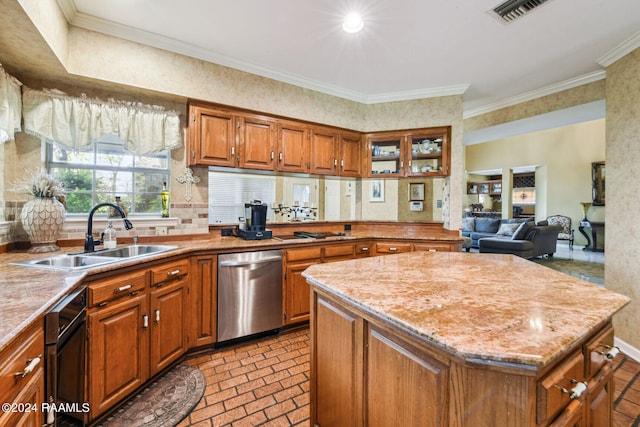 kitchen featuring stainless steel dishwasher, brick floor, a sink, and brown cabinets