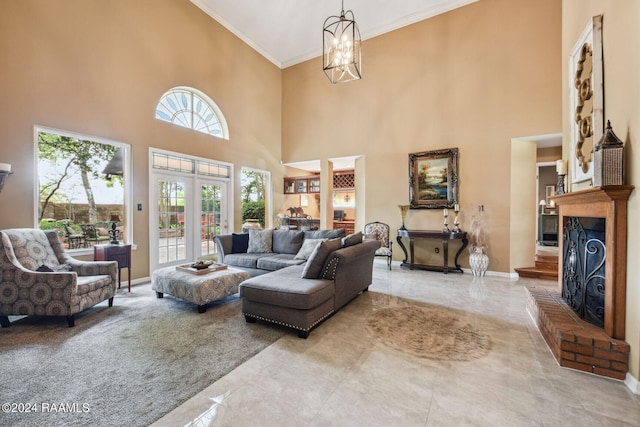 living area featuring baseboards, a fireplace with raised hearth, a towering ceiling, ornamental molding, and a chandelier