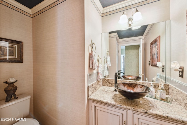 bathroom with vanity, toilet, and crown molding