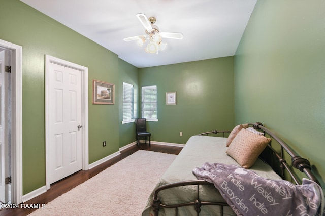 bedroom featuring dark wood-type flooring, baseboards, and a ceiling fan