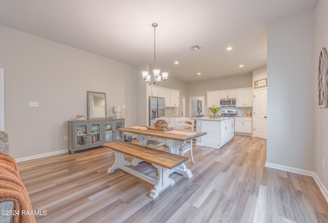 dining area featuring a notable chandelier and light hardwood / wood-style floors