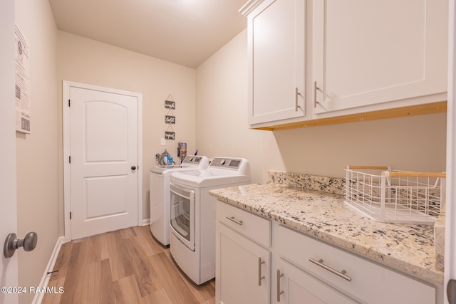 washroom featuring cabinets, separate washer and dryer, and light hardwood / wood-style floors