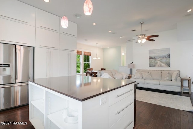 kitchen featuring a kitchen island, white cabinetry, dark wood-type flooring, stainless steel built in fridge, and pendant lighting