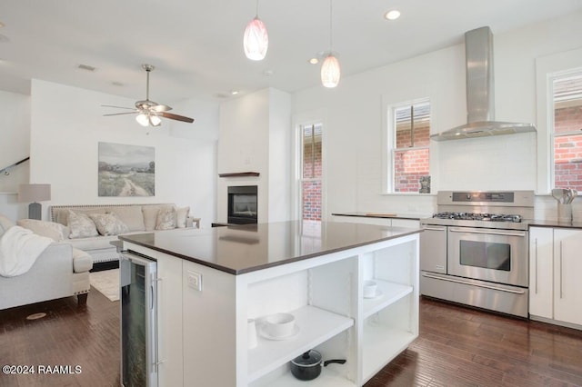 kitchen featuring backsplash, double oven range, wall chimney range hood, white cabinetry, and dark hardwood / wood-style flooring