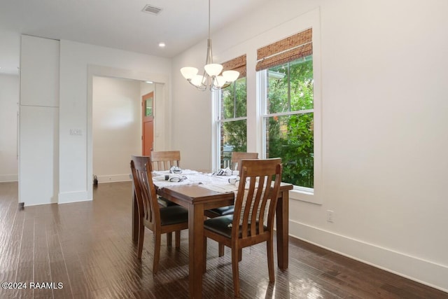 dining area with dark hardwood / wood-style flooring and a chandelier