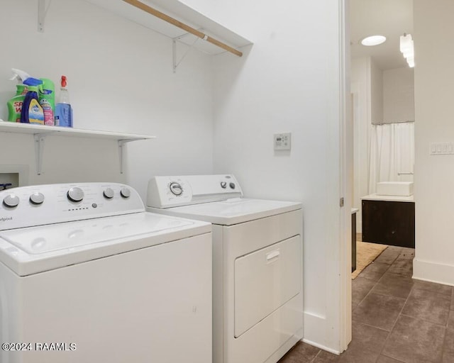 clothes washing area featuring dark tile flooring and washer and dryer