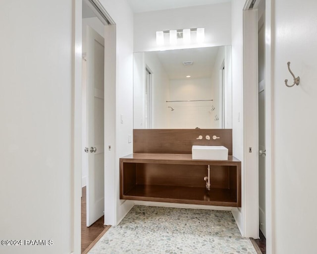 bathroom with vanity with extensive cabinet space and hardwood / wood-style flooring