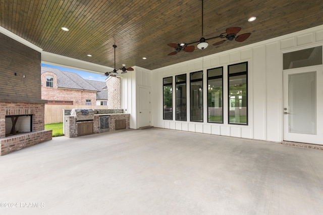 view of patio with ceiling fan, an outdoor brick fireplace, and exterior kitchen