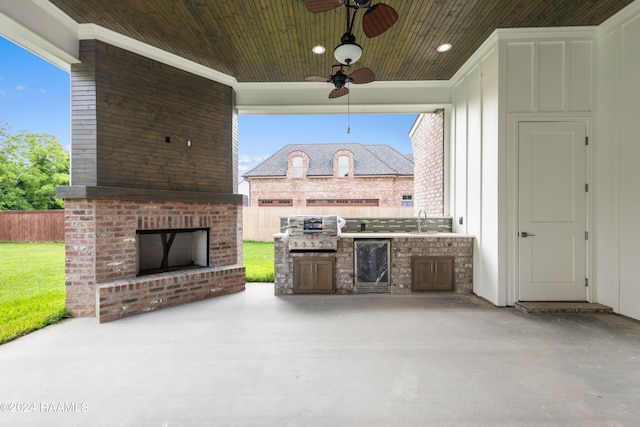 view of patio featuring area for grilling, an outdoor kitchen, ceiling fan, an outdoor brick fireplace, and sink