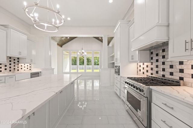 kitchen with white cabinets, vaulted ceiling, stainless steel appliances, and decorative light fixtures