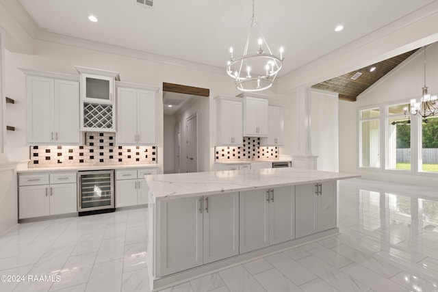 kitchen with white cabinets, wine cooler, hanging light fixtures, and a kitchen island