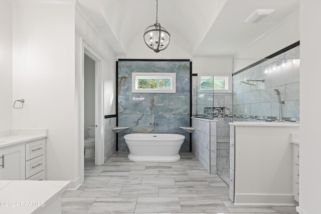 bathroom with toilet, vanity, walk in shower, a freestanding tub, and a notable chandelier