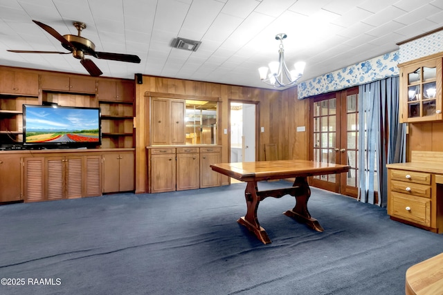 617 Cemetery Rd, Saint Martinville, LA 70582 - dining room featuring french doors, dark carpet, a chandelier, ceiling fan, and wooden walls