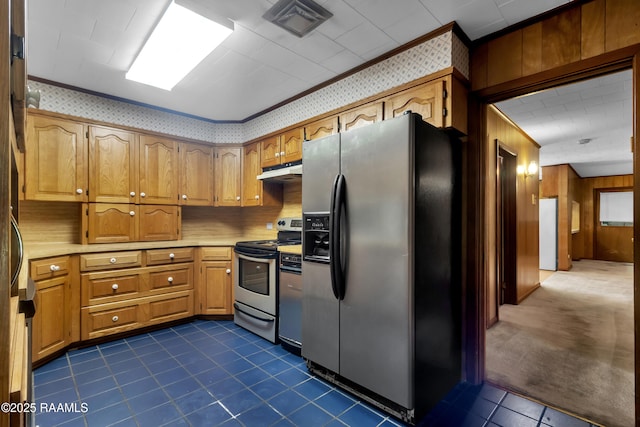 617 Cemetery Rd, Saint Martinville, LA 70582 - kitchen featuring stainless steel appliances, under cabinet range hood, brown cabinets, dark tile patterned flooring, and wooden walls