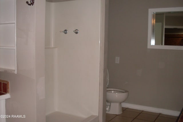 bathroom featuring tile flooring and toilet