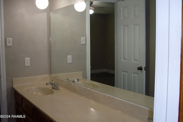 bathroom with ceiling fan and vanity with extensive cabinet space