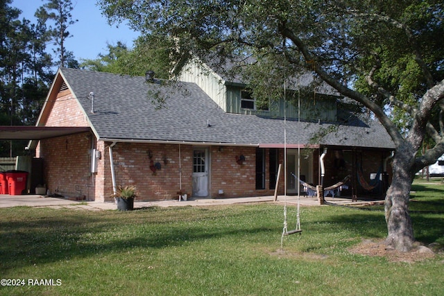 back of house featuring a carport and a lawn