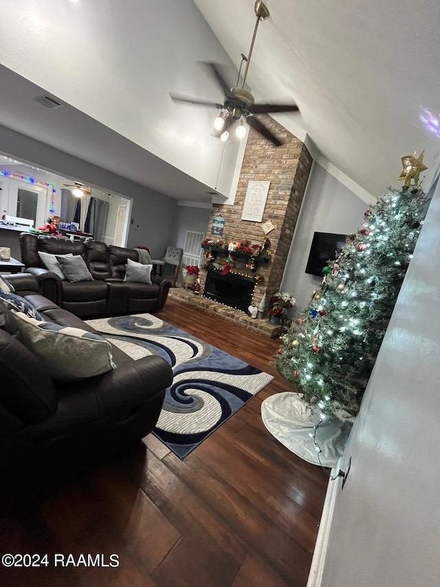 living room with brick wall, a fireplace, wood-type flooring, high vaulted ceiling, and ceiling fan