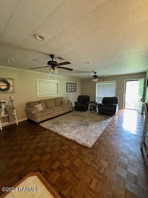 living room with ceiling fan and dark parquet flooring