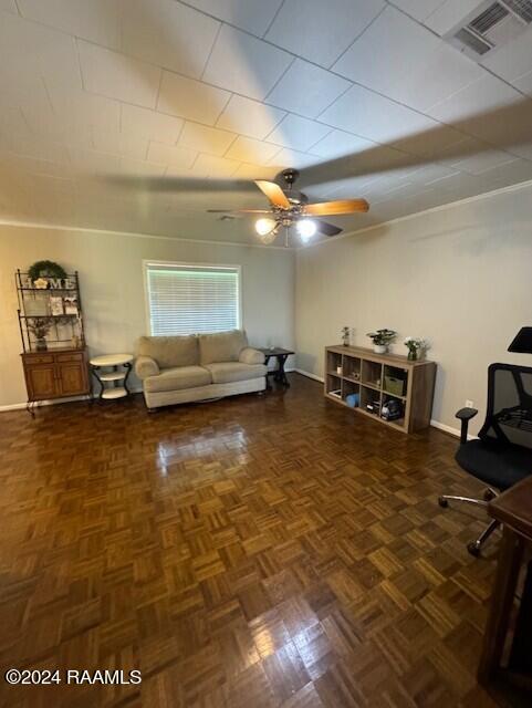 living room with dark parquet flooring and ceiling fan