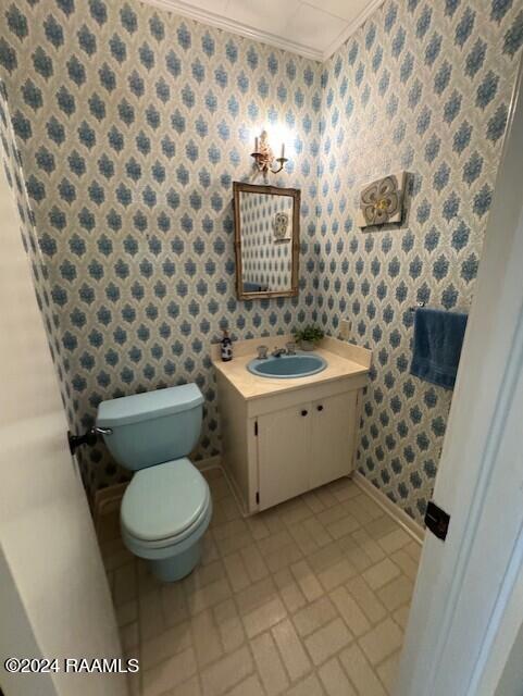 bathroom featuring crown molding, vanity, and toilet