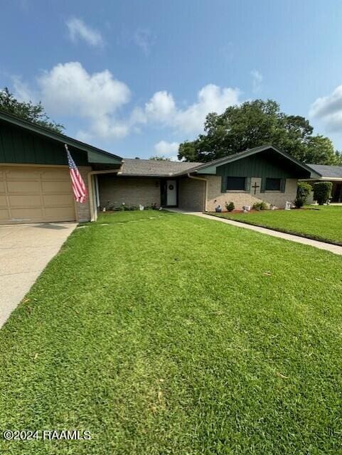 ranch-style house featuring a front yard and a garage